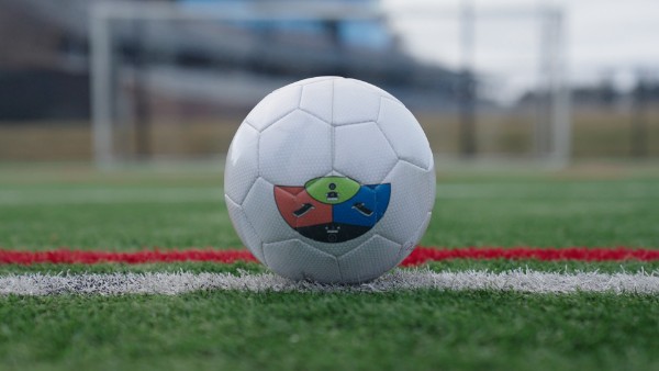 KickMap Trainer strike map with colored contact zones applied to a soccer ball on a training pitch
